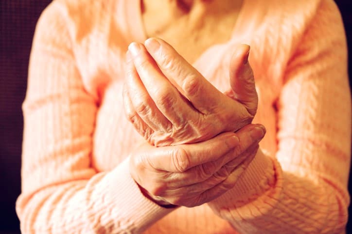 Older woman rubbing hands